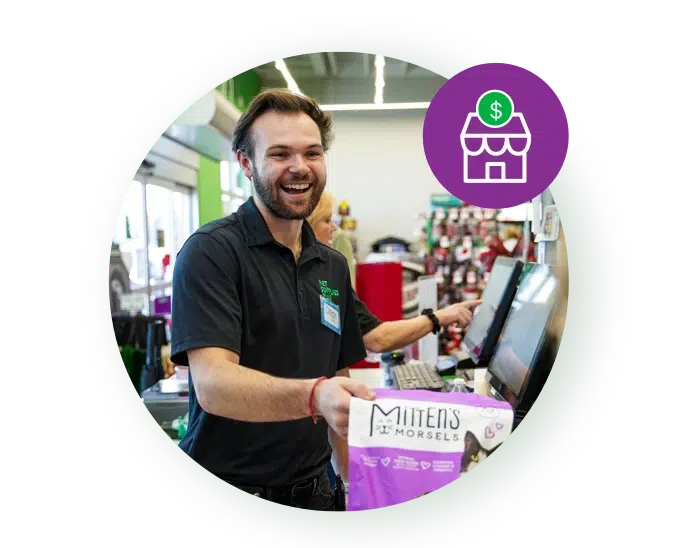 Smiling Pet Supplies Plus team member ringing up a customer at the register